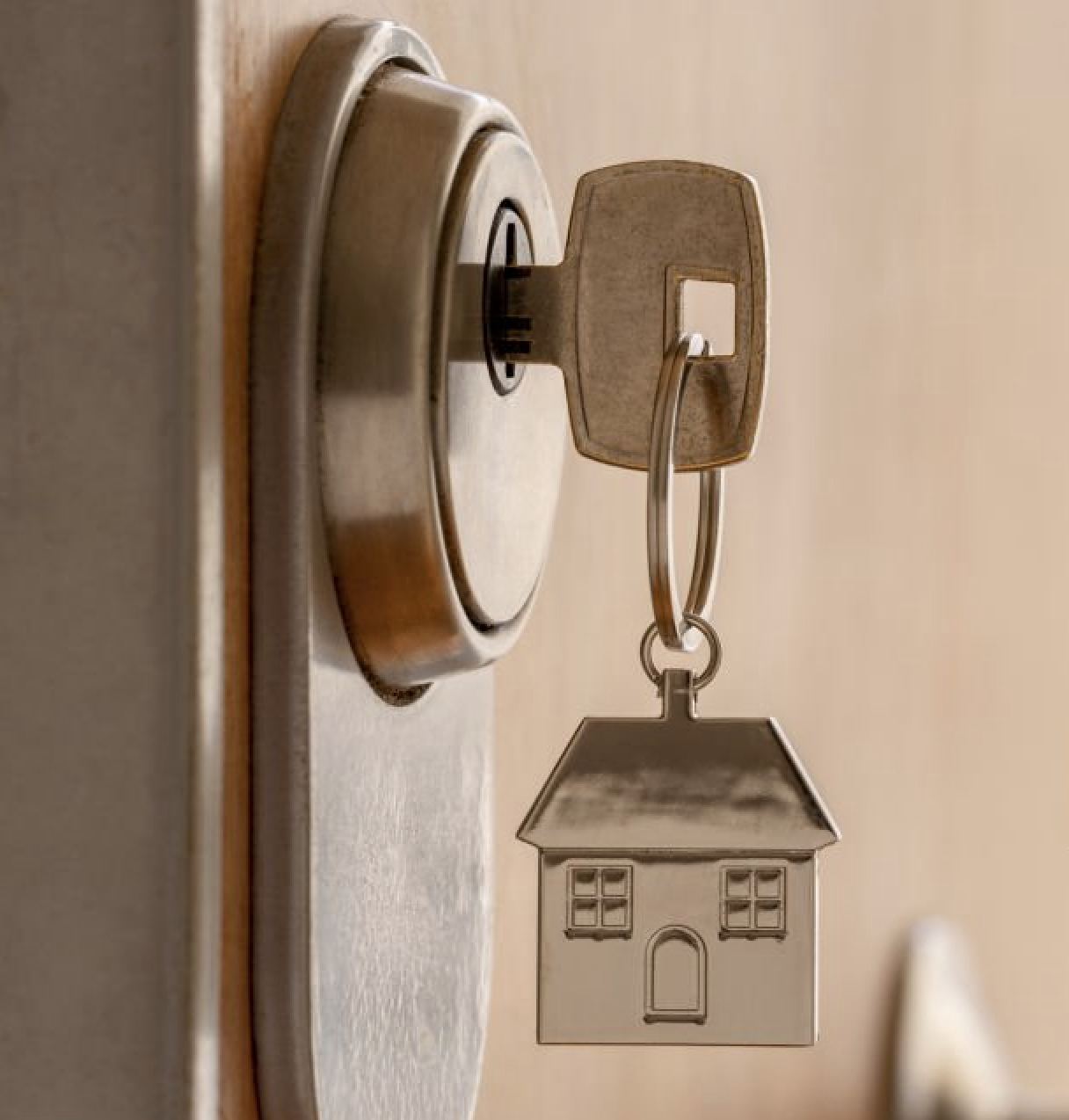 Llave con llavero en forma de casa en una cerradura