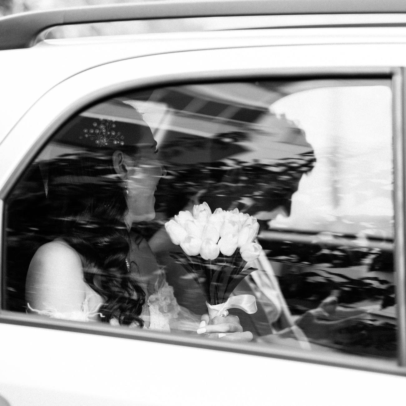 Pareja de novios besándose vistos a través de la ventanilla de un coche